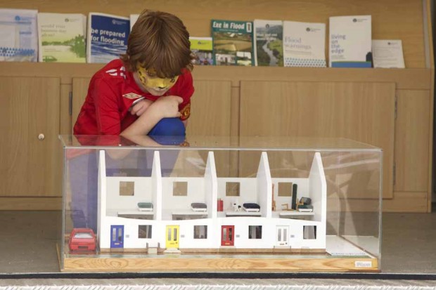 A boy studies our flooded house model