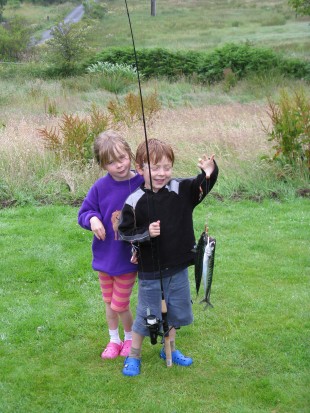 2 children, 1 boy and 1 girl holding up a fish