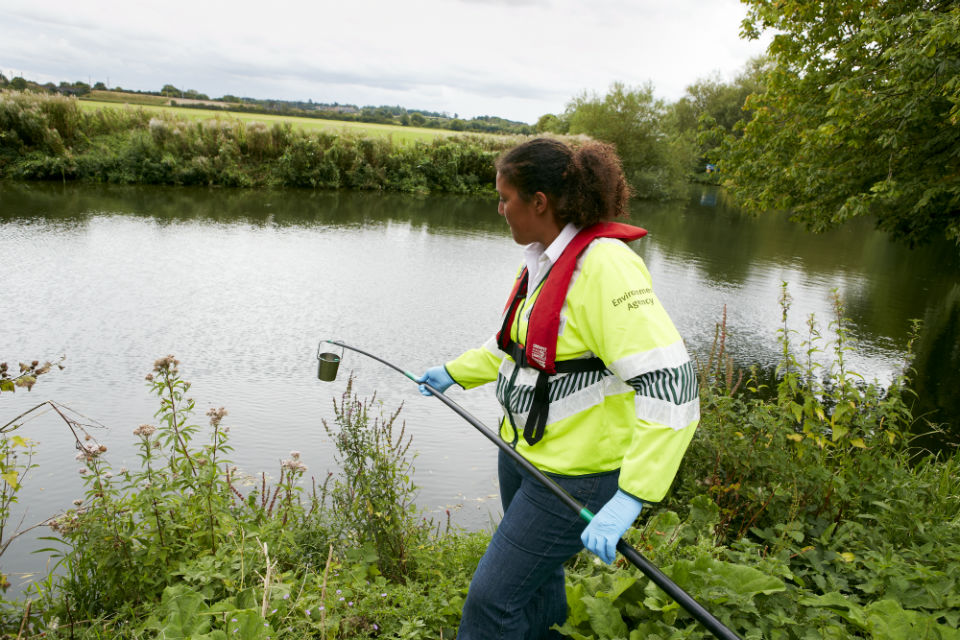 An Environment Officer samples a river for pollution