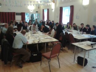 Catchment partnership meeting. Four groups of people sitting at tables in a meeting room