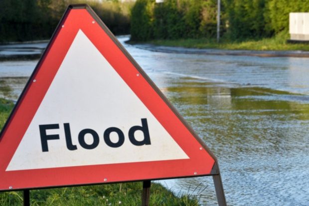 flood sign in front of flood water