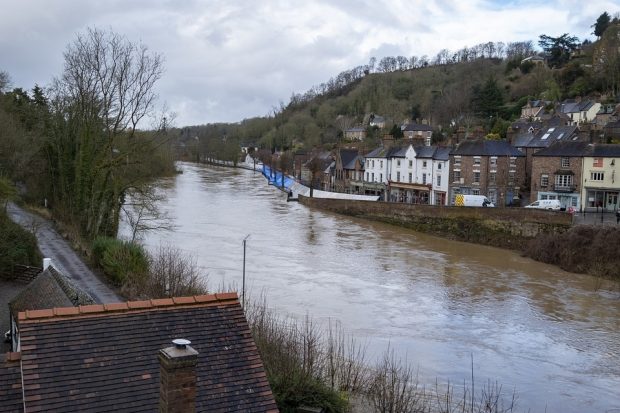 swollen river in front of some houses