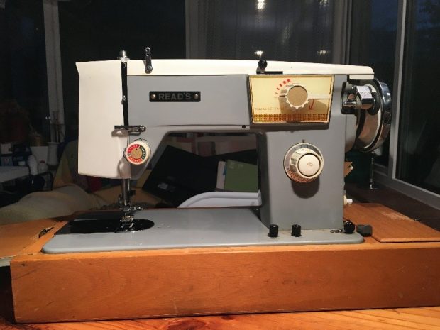 Grey sewing machine with a wooden base
