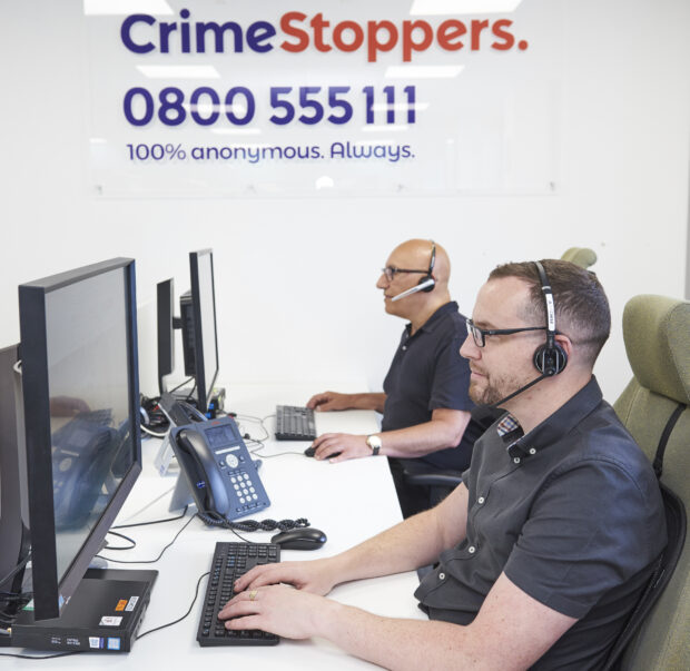 Promotional image for Crimestoppers showing two men answering calls in an office