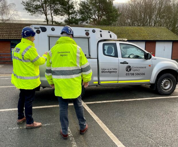 Environment Agency and HMRC officers in front of a van.