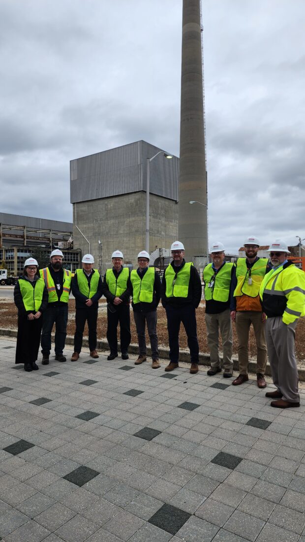 Group of people in protective gear standing outside a decommissioned nuclear facility