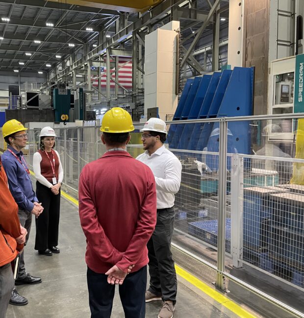 Group of people in protective gear on a tour of a nuclear manufacturing centre