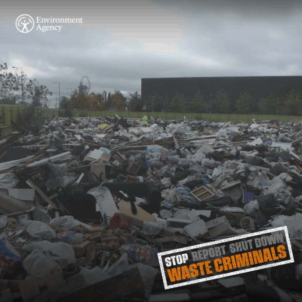 Image shows Environment Agency Officer on the scene at vacant land filled with large quantity of waste illegally dumped by criminals.