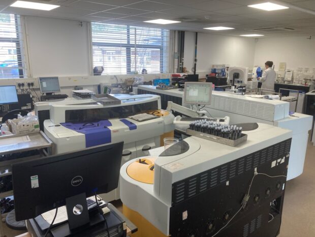 An internal view of the Environment Agency's Starcross Labs with computers, machinery, test tubes and a scientist in the background