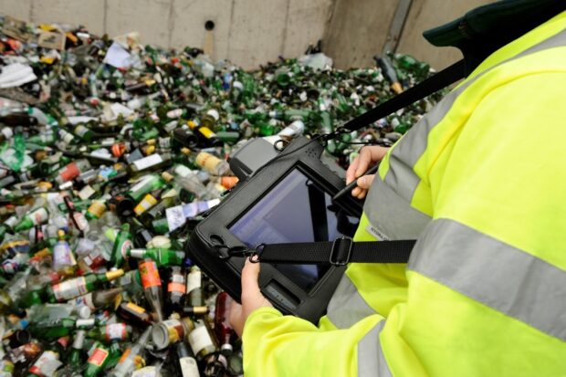 Environment Agency staff using a new electronic system for regulating waste returns at a bottle recycling plant. 