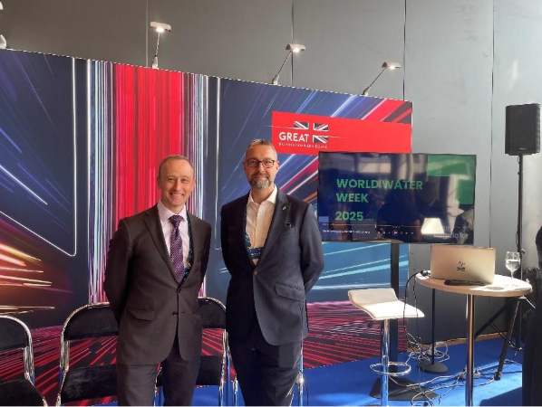 Rob Bradburne and John Leyland stood in front of a large, stylised Union Flag banner