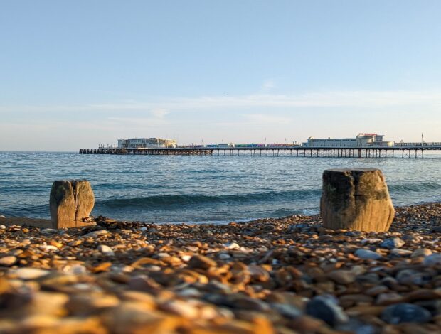 A pier and beach on a sunny morning overlooking the sea. 