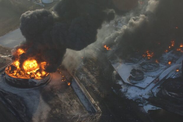 Large clouds of smoke above a building on fire.