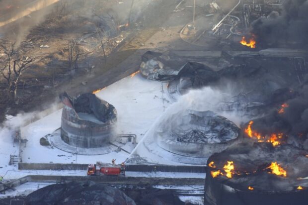 Foam being sprayed onto a burnt building by fire engines.