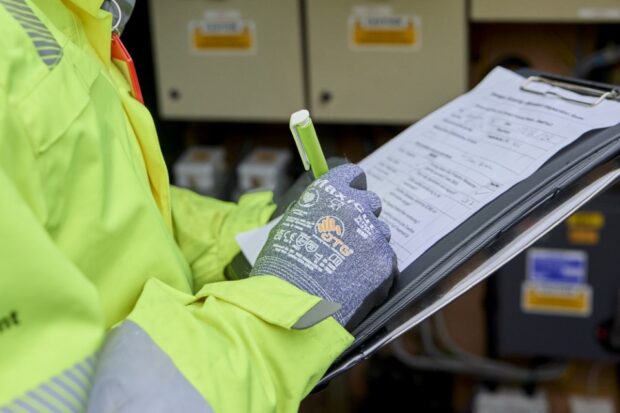 An Environment Agency officer makes notes on an inspection sheet.