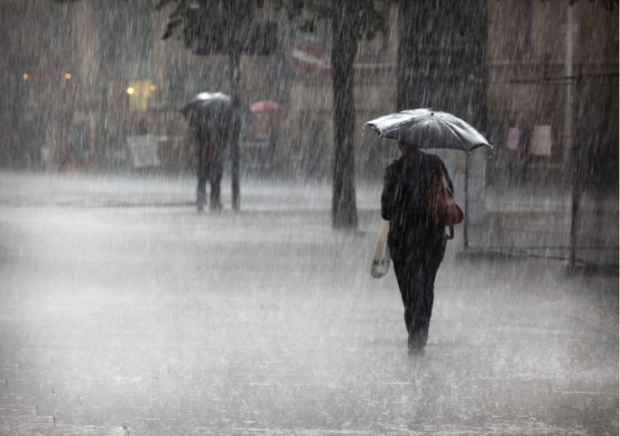 A commuter walking through flooding in London.