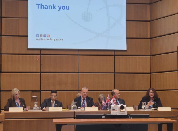 Five delegates including Jo Nettleton seated on a conference panel at the International Atomic Energy Agency headquarters, beneath a presentation screen displaying “Thank you” and the Canadian Nuclear Safety Commission website