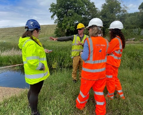 Officers in helmets discussing the work at the River Rib while stood next to it.